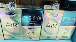 A shelf in a store displays several boxes of Durex AiR condoms with holographic packaging and Chinese text.