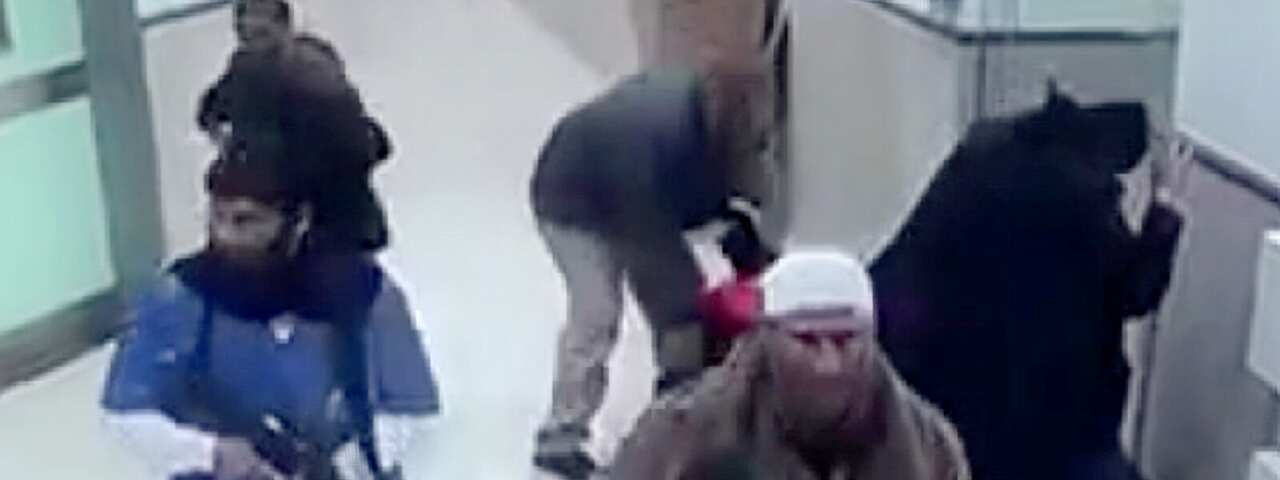 People seen on TTV walking through a hospital. Two are holding weapons.