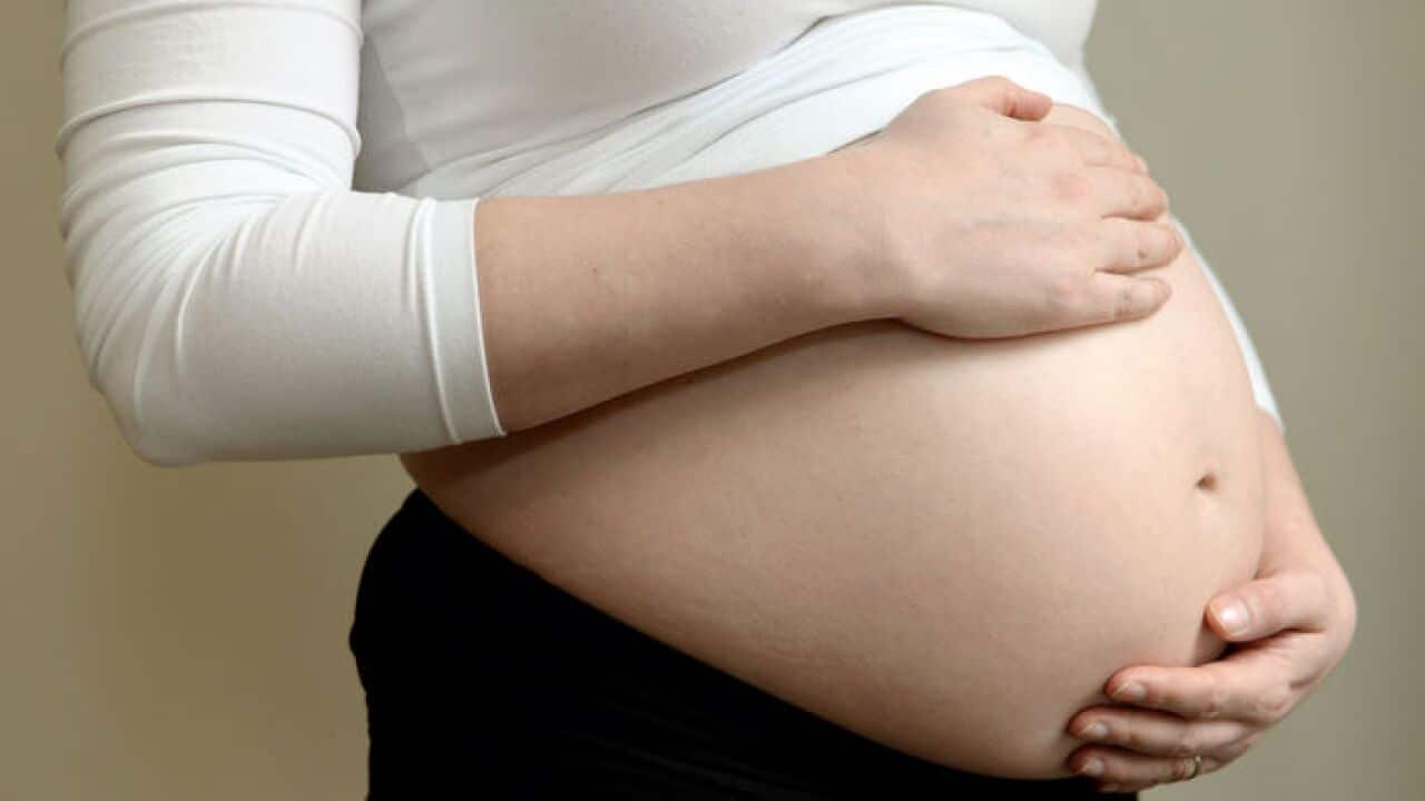A woman seven months into her pregnancy.