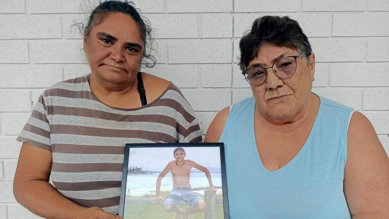 2. George’s mother Karen Campbell (L), and George’s grandmother Fay Campbell (R) stand with a picture of George before the coronial inquest.  .png