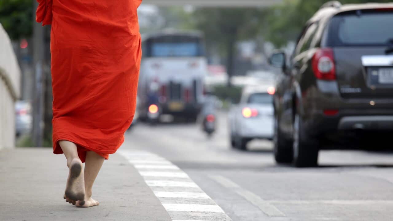 File photo of a Buddhist monk, barefoot and clothed in traditional orange-colored robes, in Bangkok, Thailand.