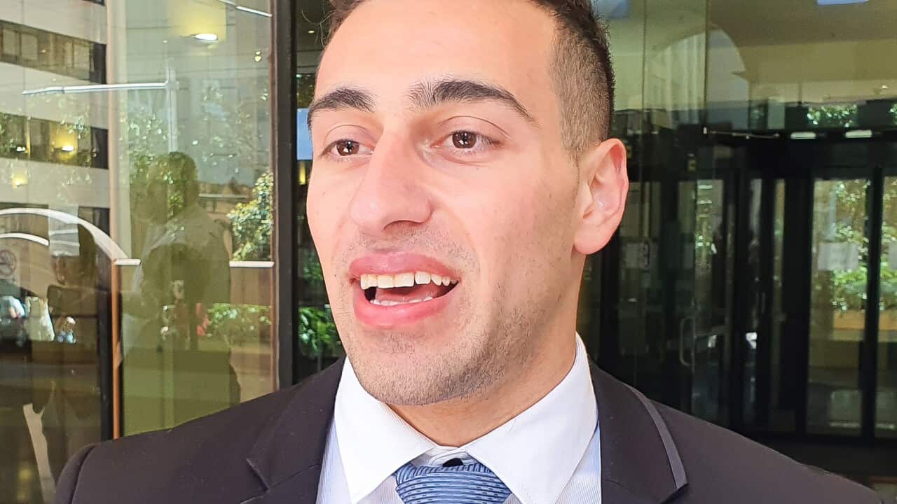 A man in a suit and tie outside a court.