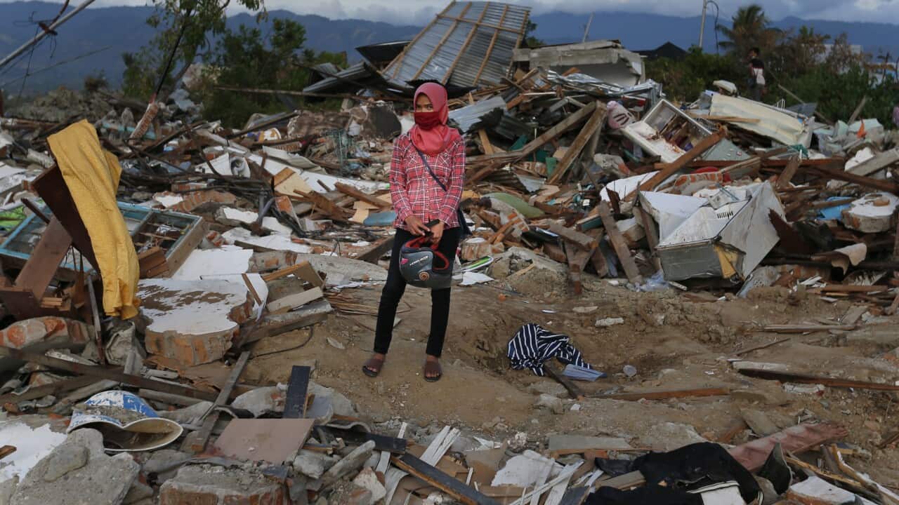A woman stands on the rubble of houses at Petobo neighborhood which was wiped out by earthquake-triggered liquefaction in Palu, Central Sulawesi