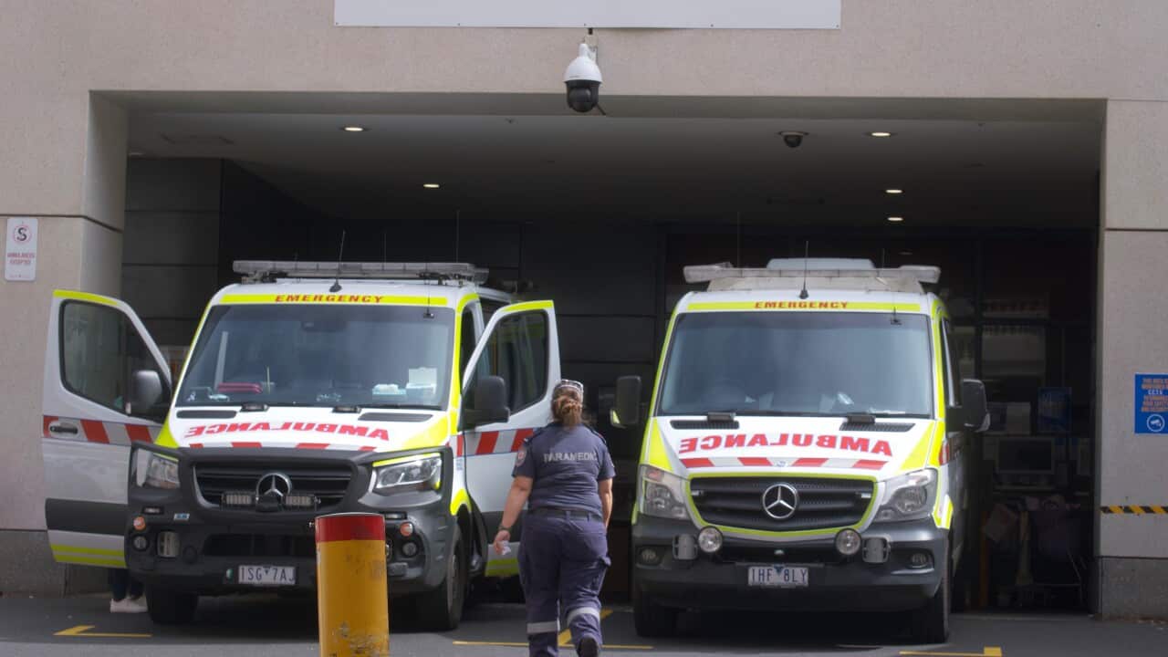 Paramedics are seen tending to their ambulance outside St. Vincent's hospital in Melbourne.