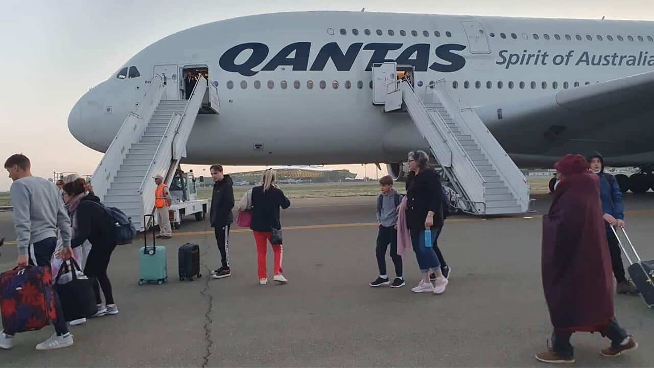 Passengers disembark from an a plane.