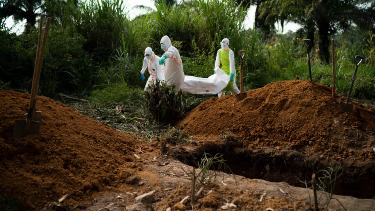 Workers bury the remains of an Islamic scholar who had prayed over those who were sick but then himself died of Ebola