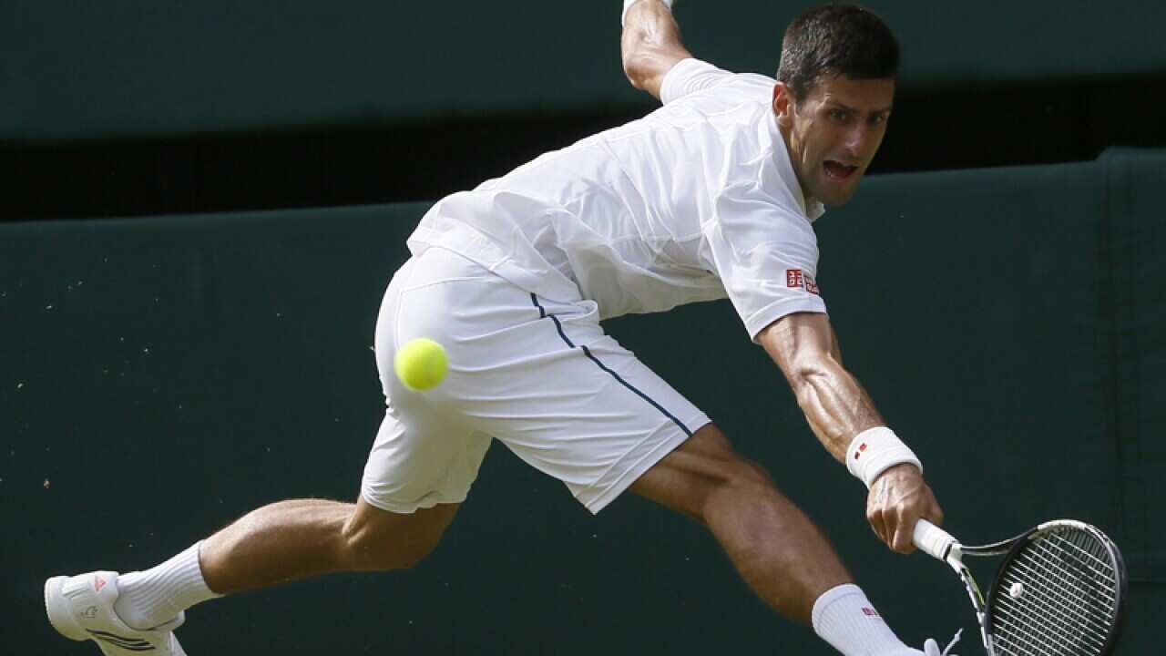 Novak Djokovic of Serbia returns a ball to Bernard Tomic of Australia