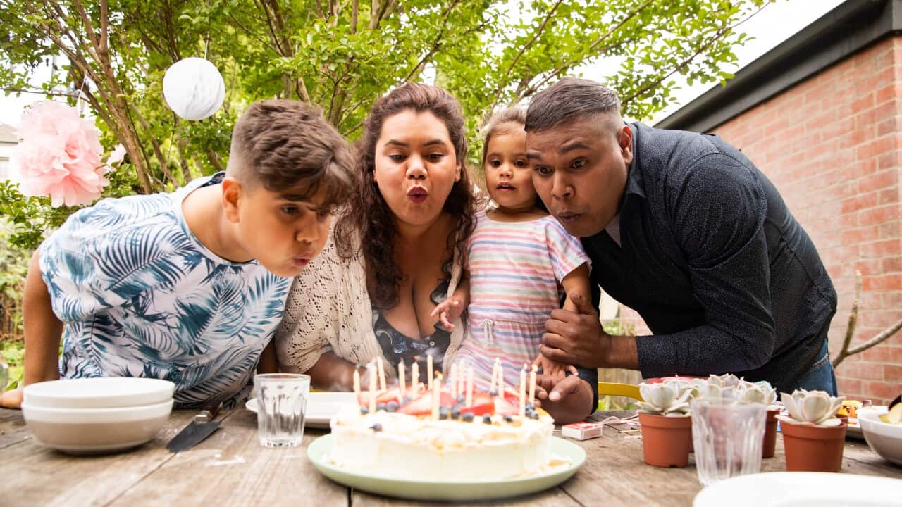 People blowing candles on a cake