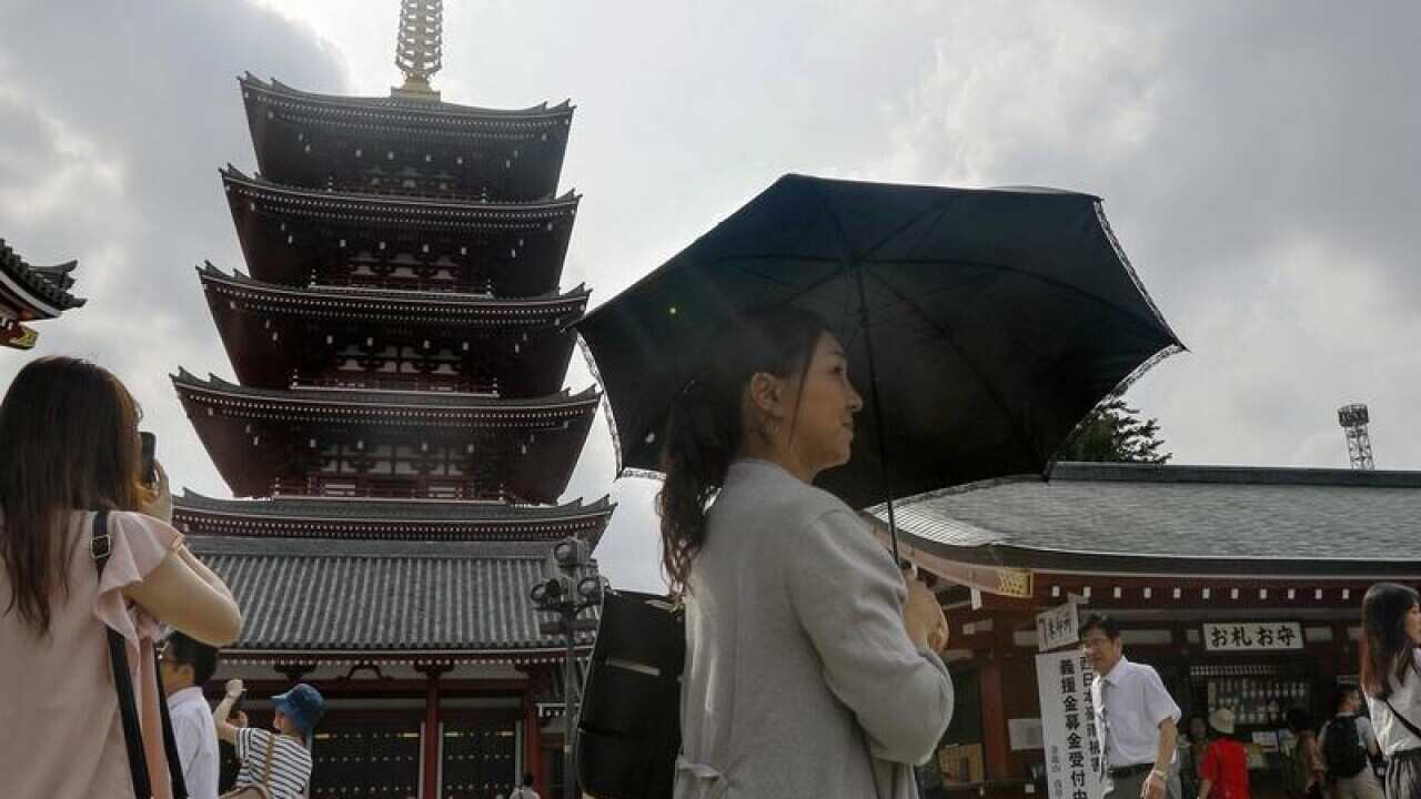 A woman uses a parasol at the Sensoji temple in Tokyo