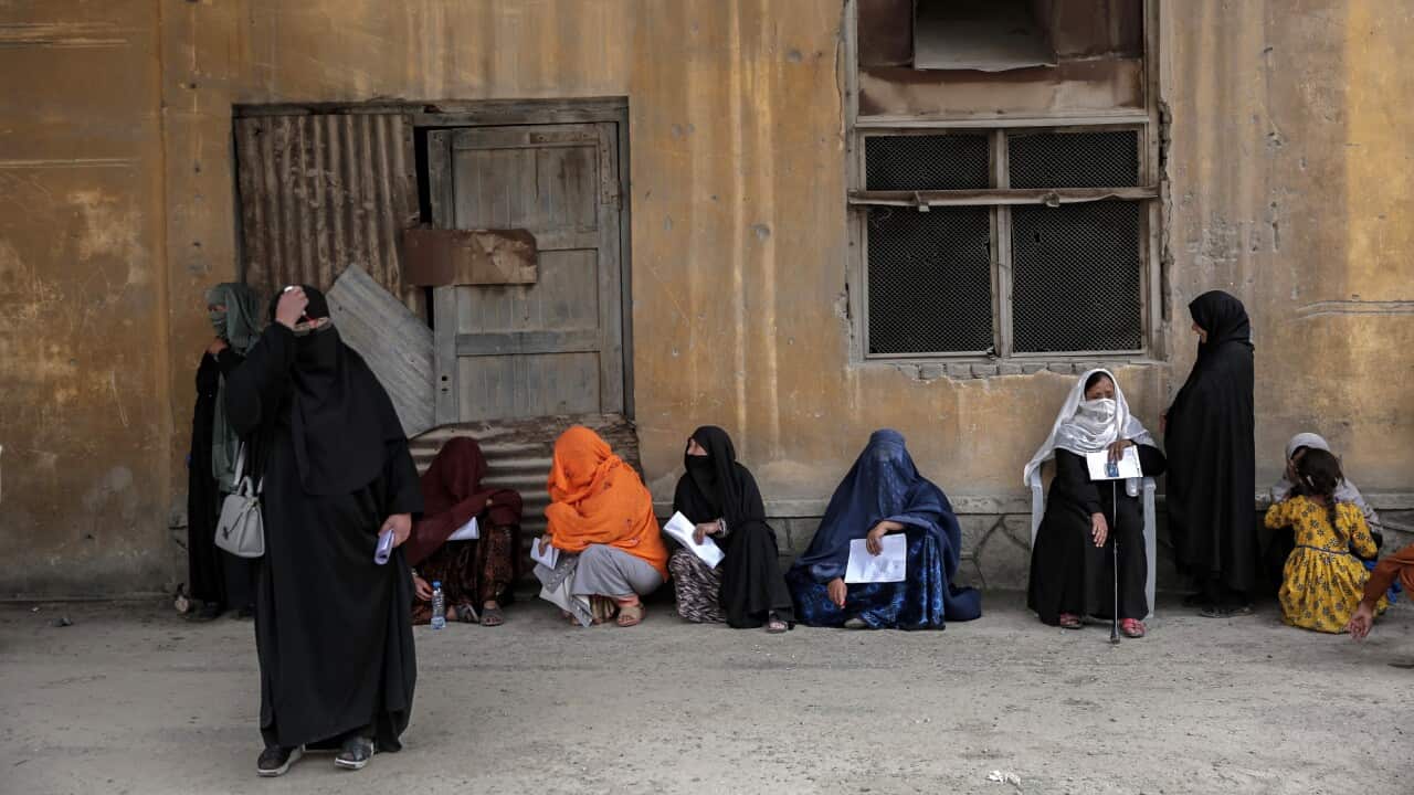 Women wait for aid in Kabul
