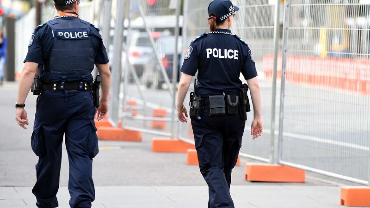 Police officers patrol a perimeter fence for the G20 in Brisbane