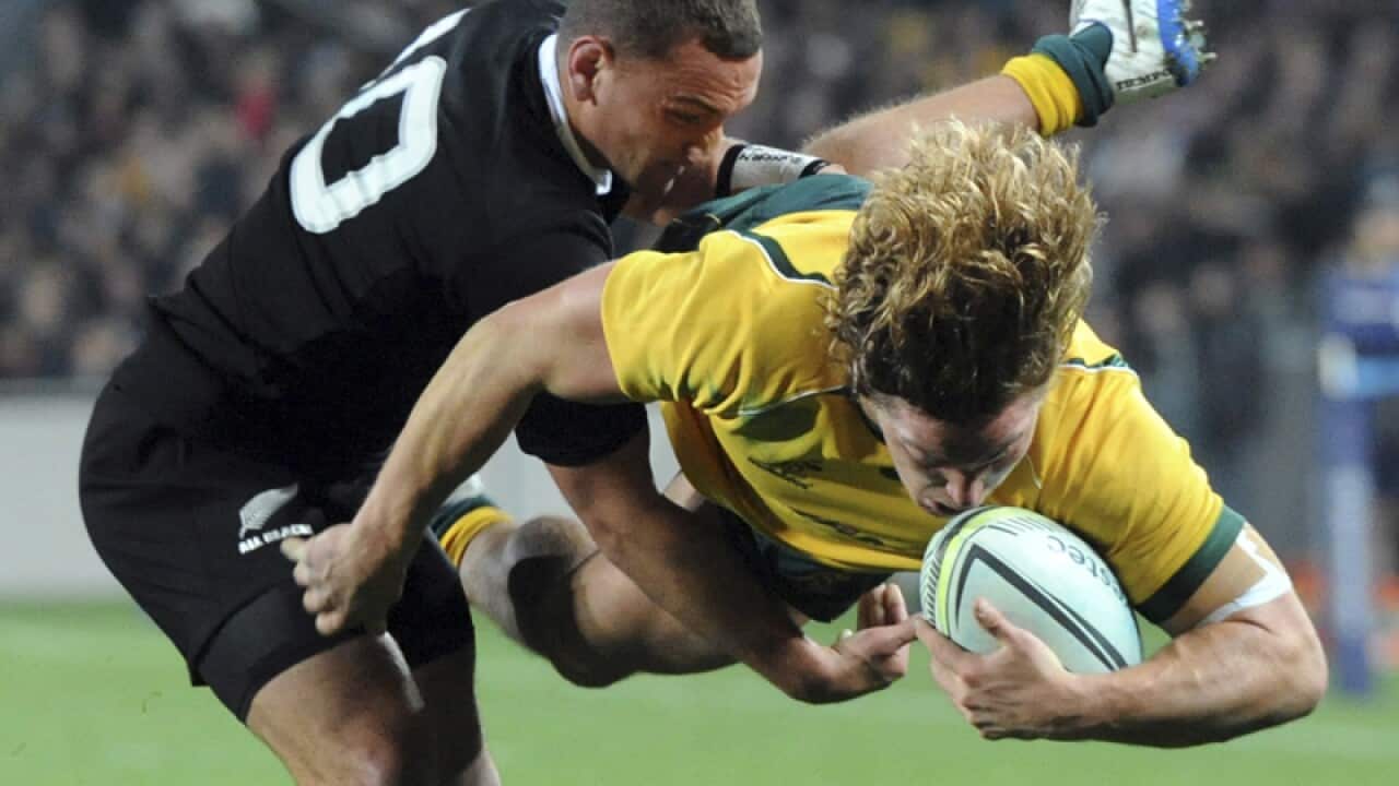 Australia’s Michael Hooper, right, is taken in a tackle
