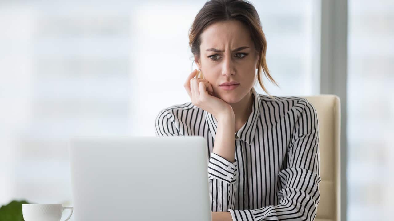 Confused businesswoman annoyed by online problem looking at laptop