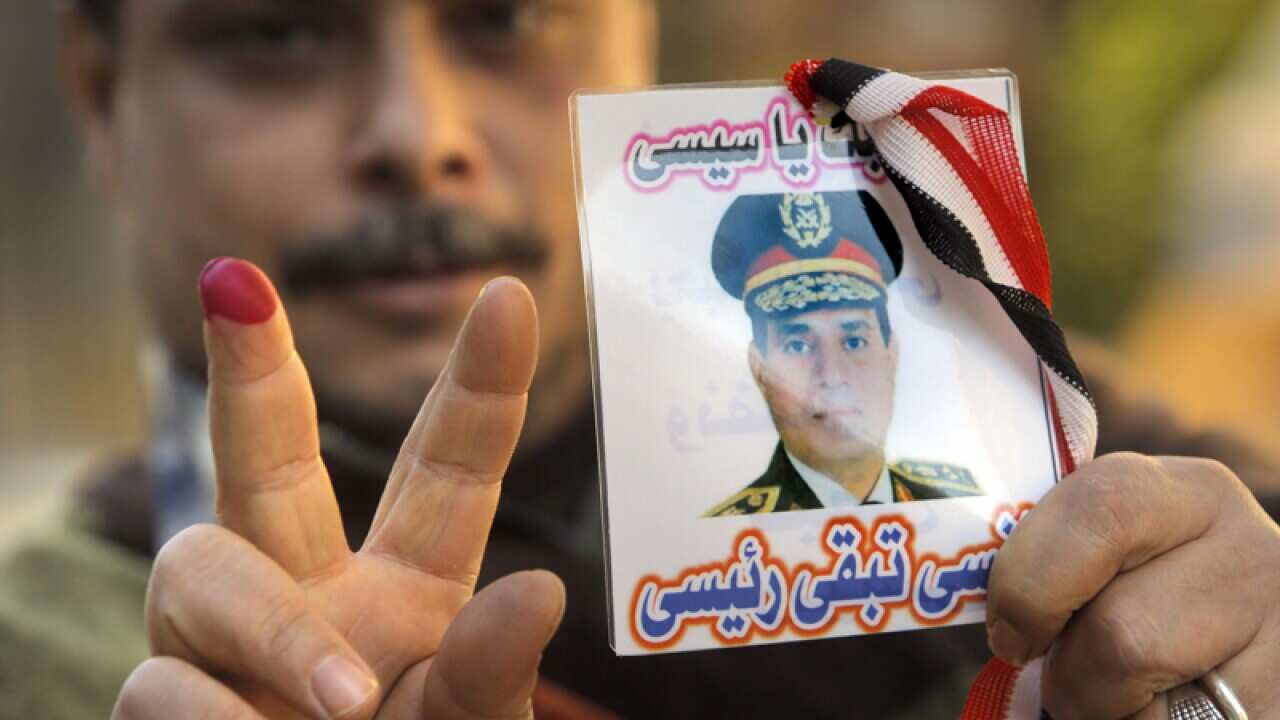 An Egyptian voter holding up a card