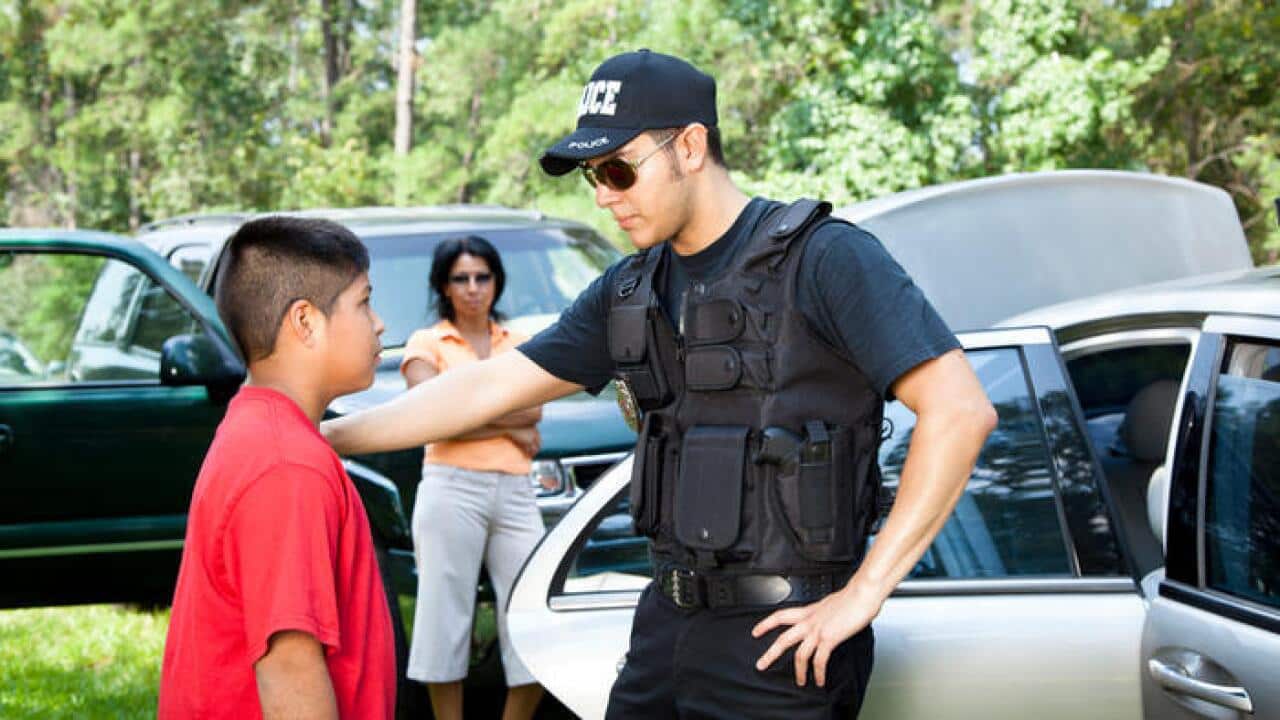 Policeman questioning witnesses during crime investigation