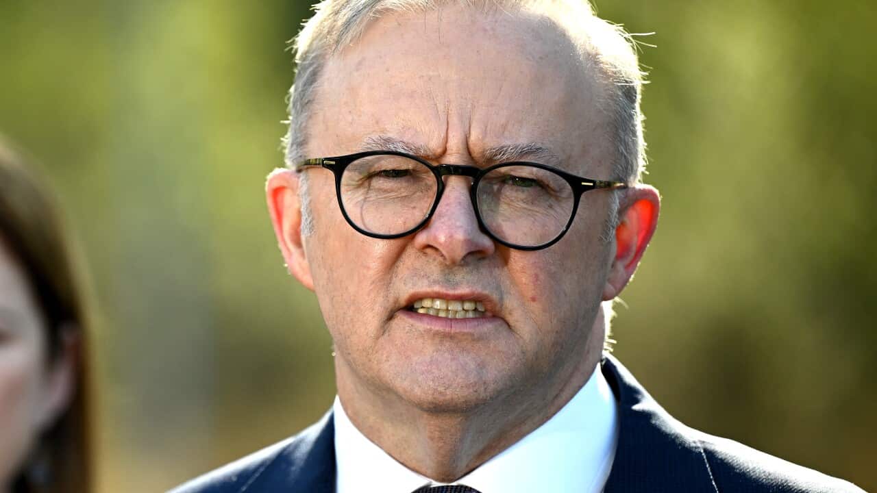 Man in suit and glasses talking.