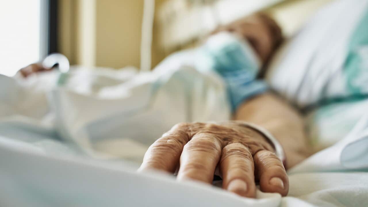 A blurred woman wearing face mask lying on hospital bed.
