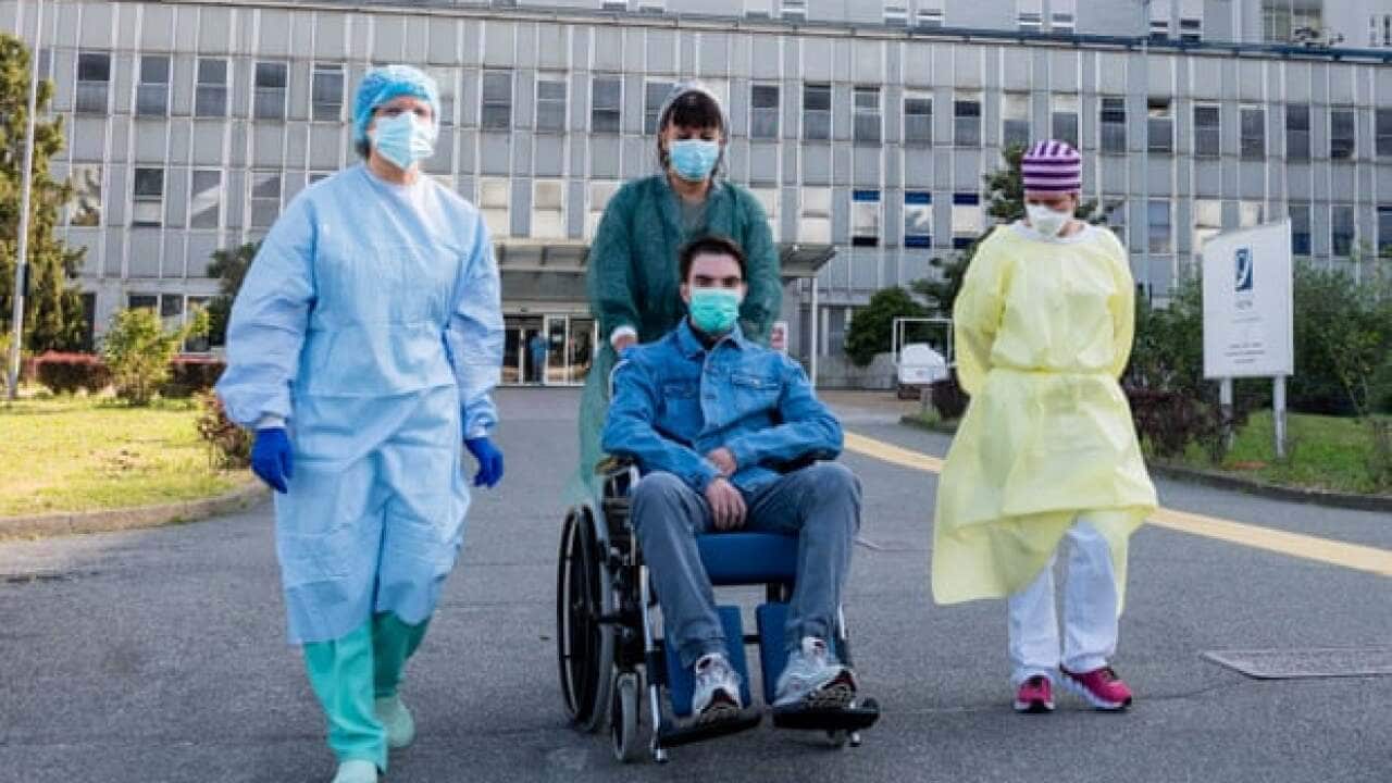 A patient who had severe Covid-19 is discharged from a hospital in Italy.