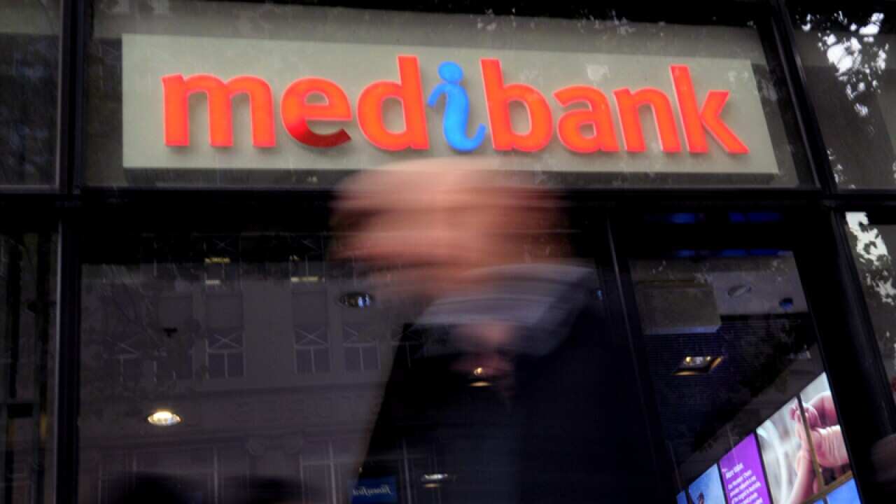 Pedestrians walk past a Medibank outlet in Melbourne