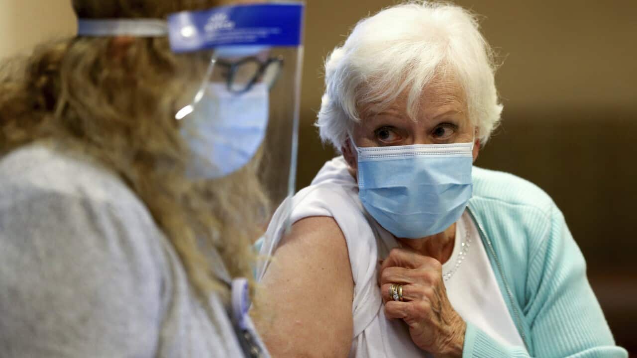 A woman receives her first dose of the COVID-19 vaccine.
