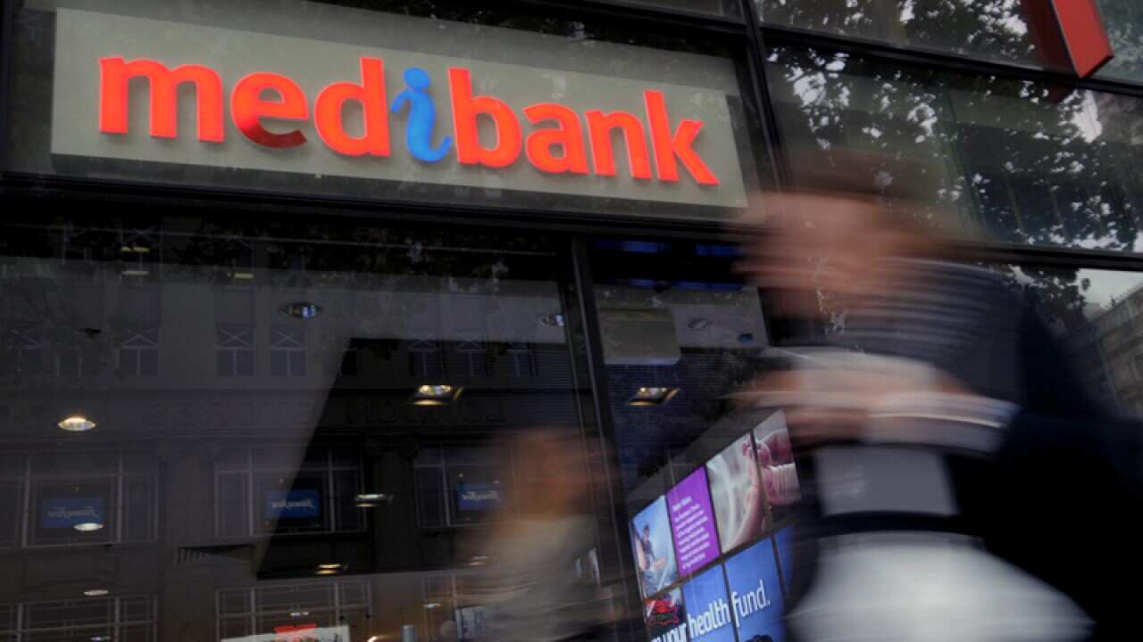 Pedestrians walk past a Medibank outlet in Melbourne
