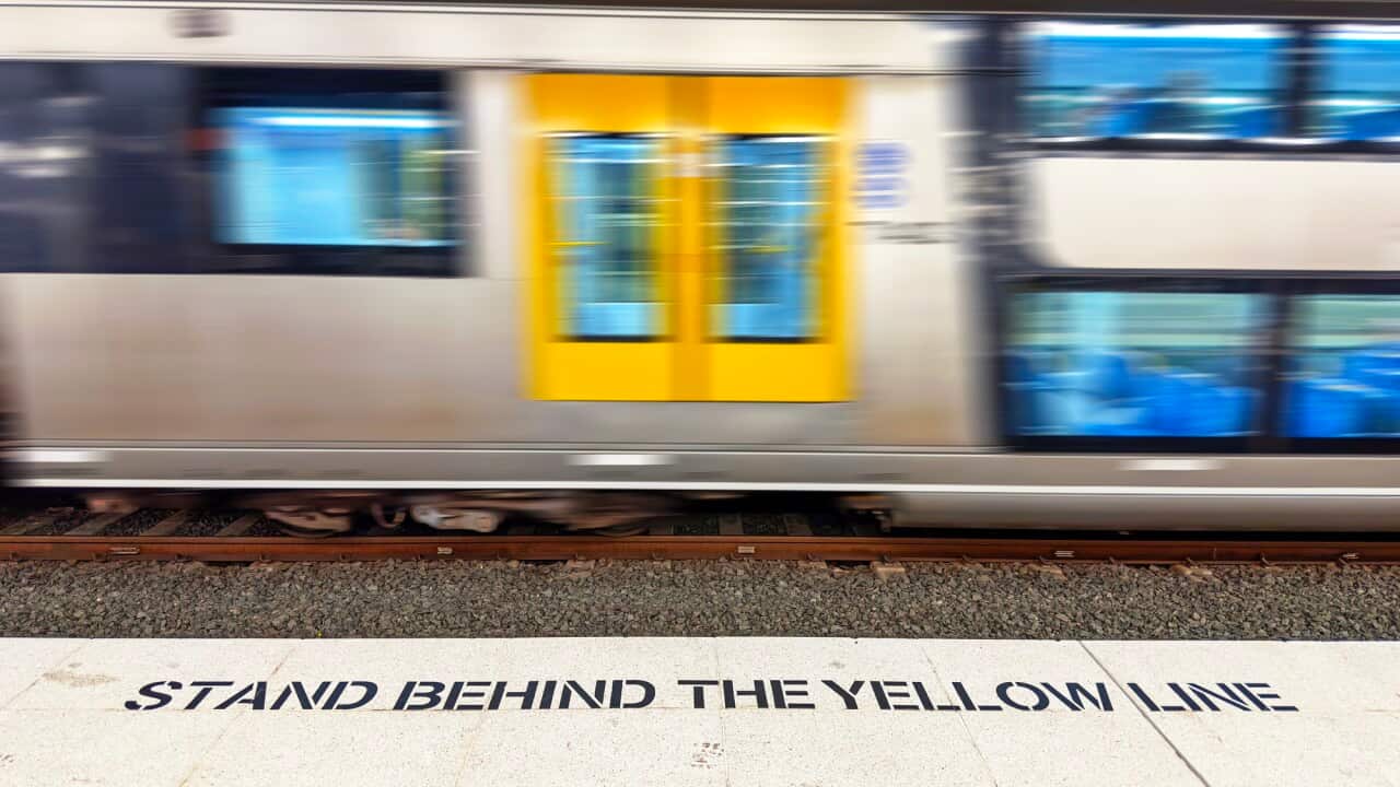 Stand behind the yellow line sign on train platform