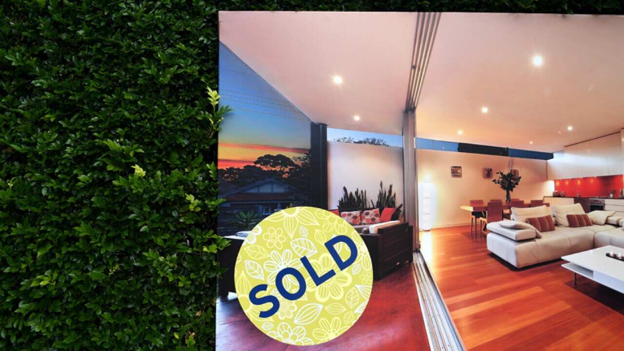 A for sale sign in front of a house in Sydney