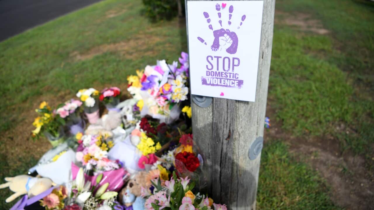 FATAL CAR FIRE BRISBANE a sign reads Stop Domestic Violence placed at a makeshift shrine