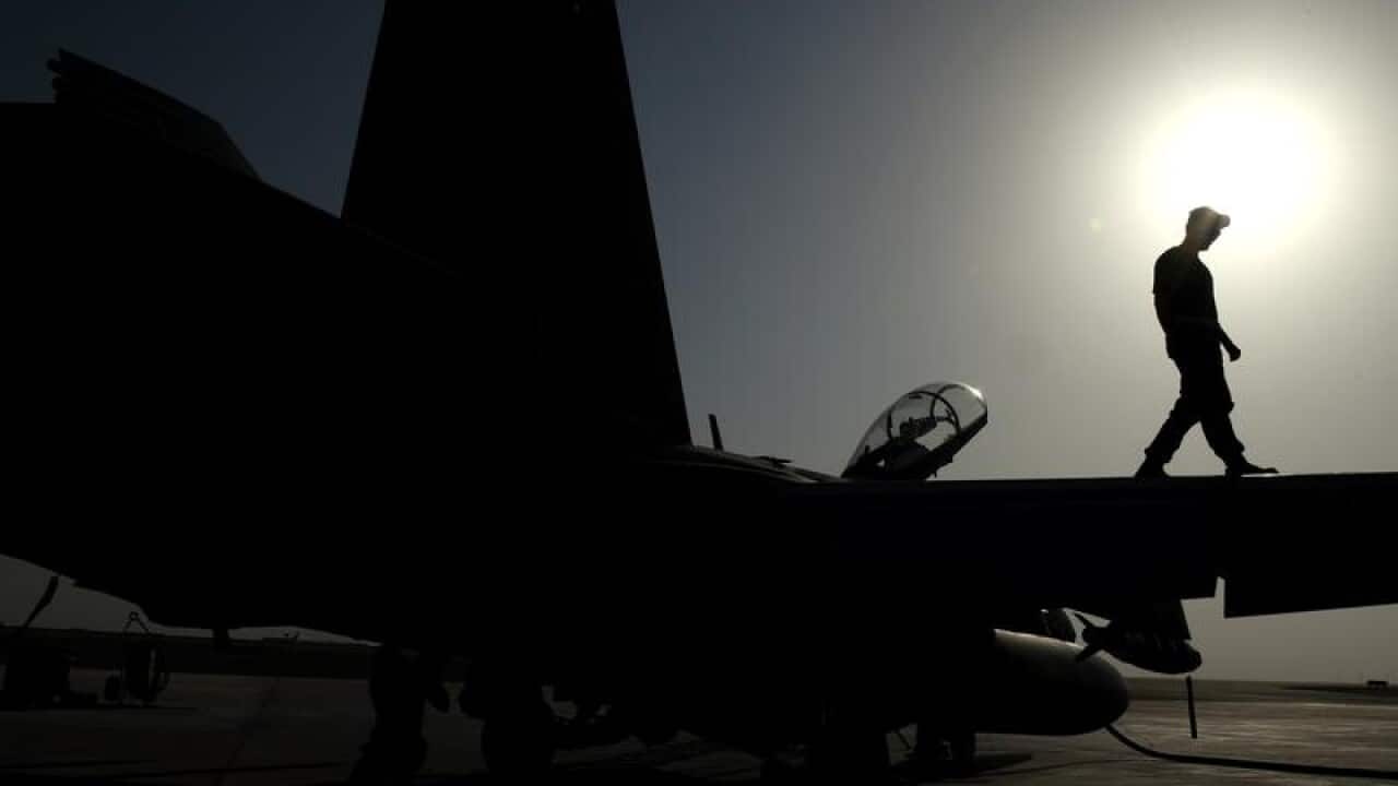 Royal Australian Air Force maintainers prepare an F/A-18F Super Hornet