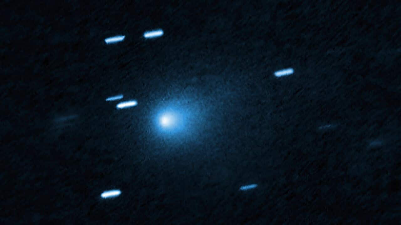 Interstellar A bright blue comet-like object against a dark sky with streaked star trails.