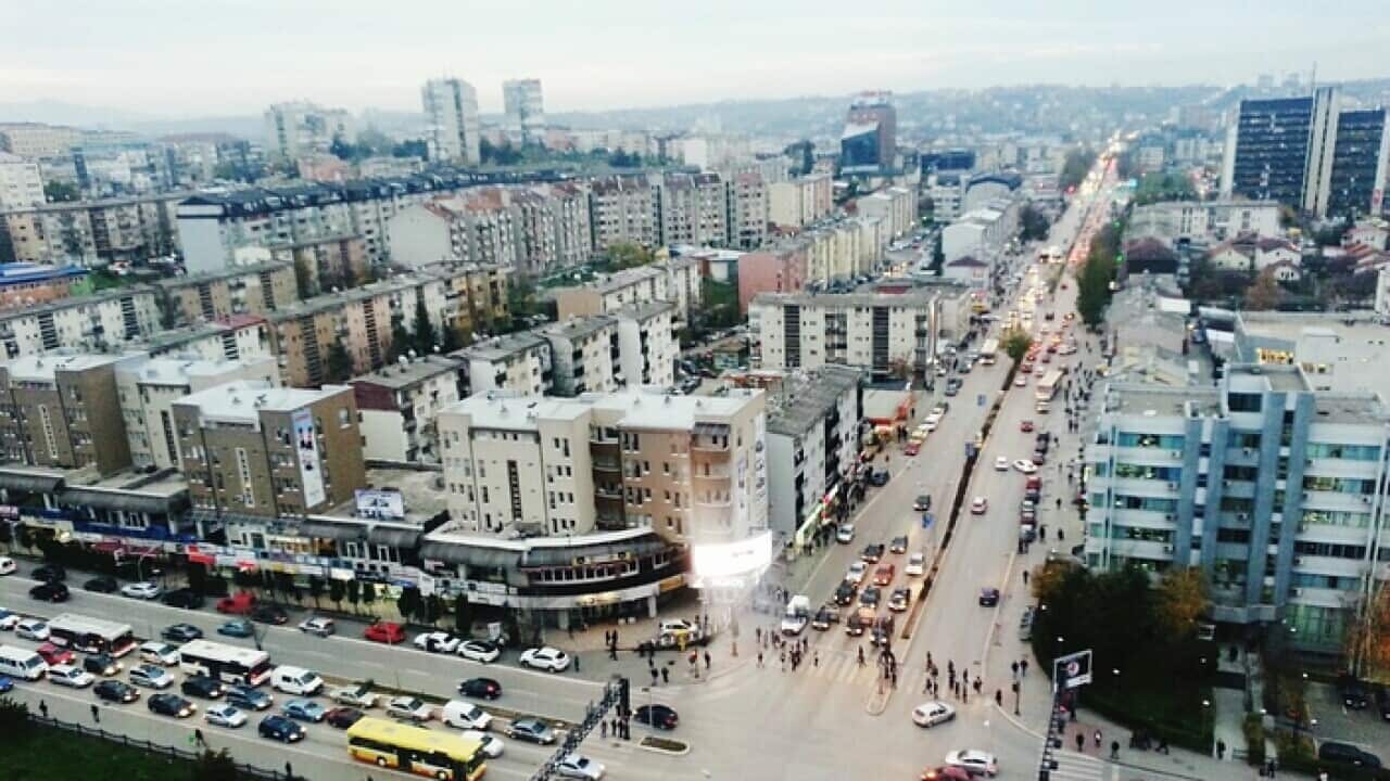 High Angle View Of Vehicles On Road By Buildings In City