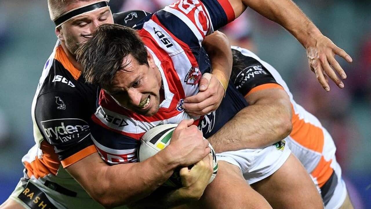 Mitchell Pearce of the Roosters is tackled by Matthew McIlwrick