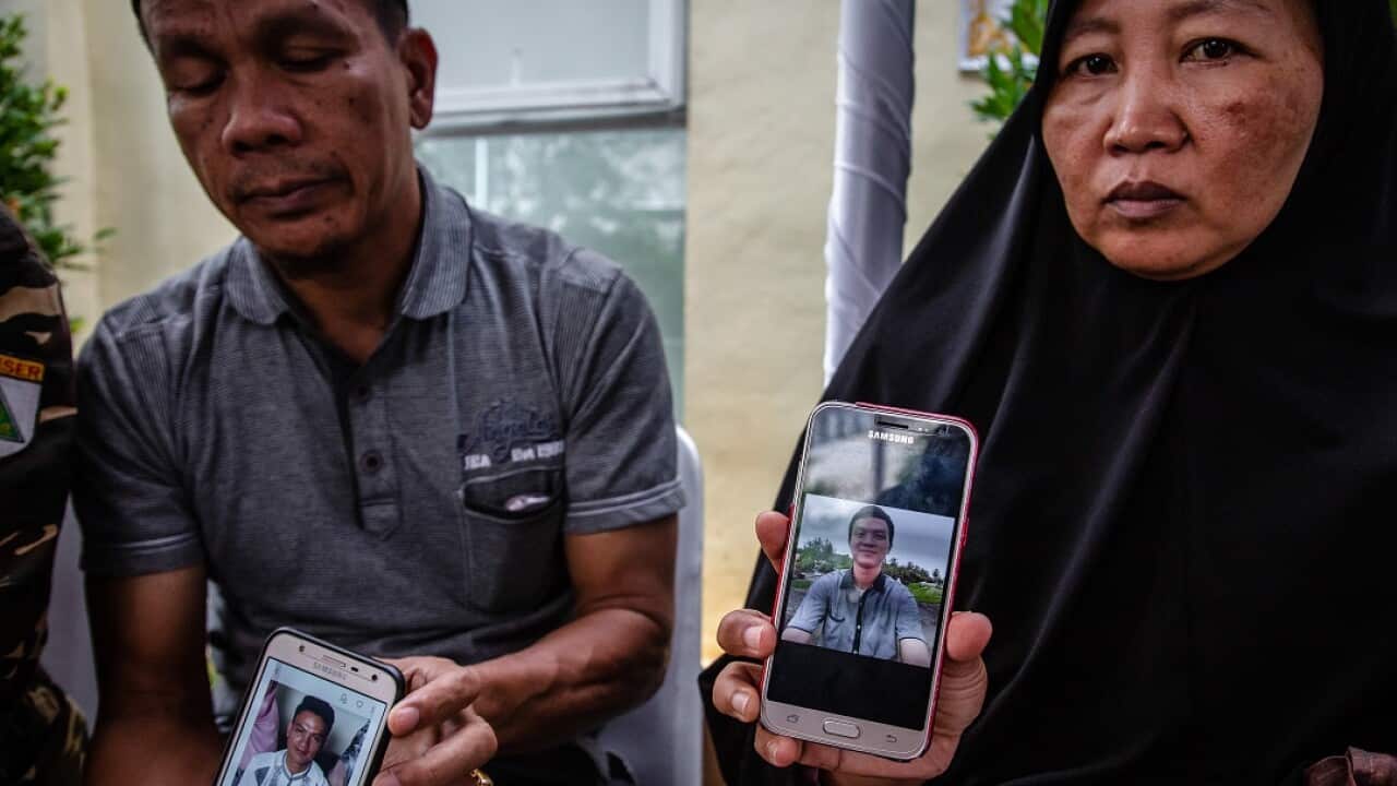 Families of the victims show pictures of their loved ones as they await news over the location of the black box.