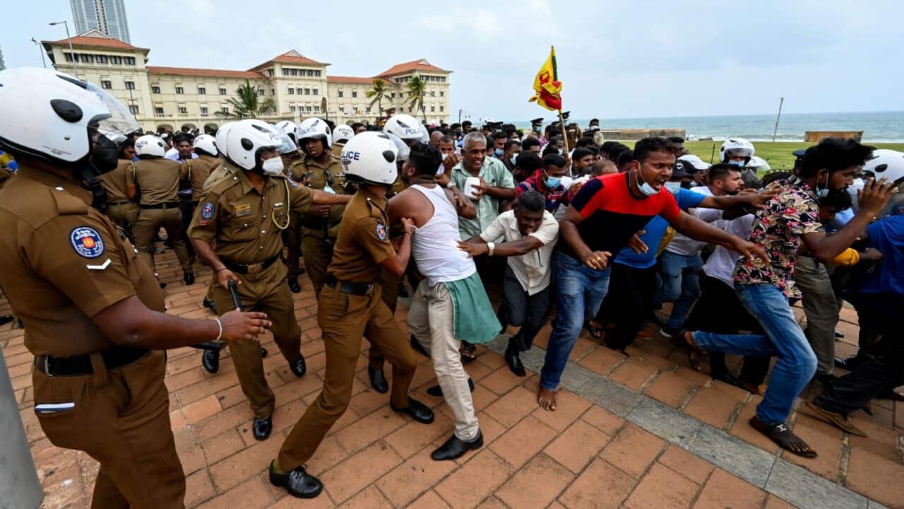 Government supporters and police clash outside the President's office in Colombo on May 9, 2022