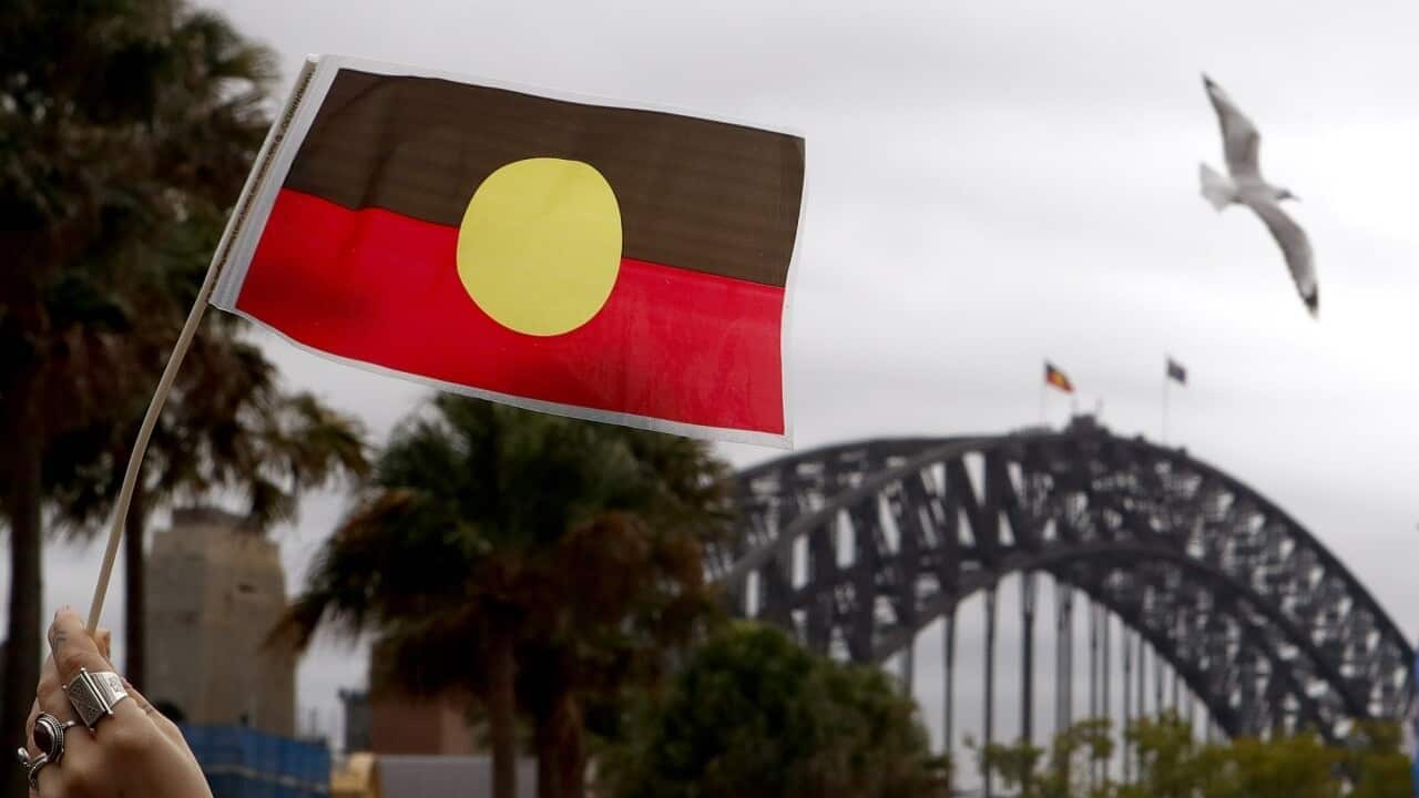 Aborignal flag erected with Australian flag on Sydney Harbor bridge.
