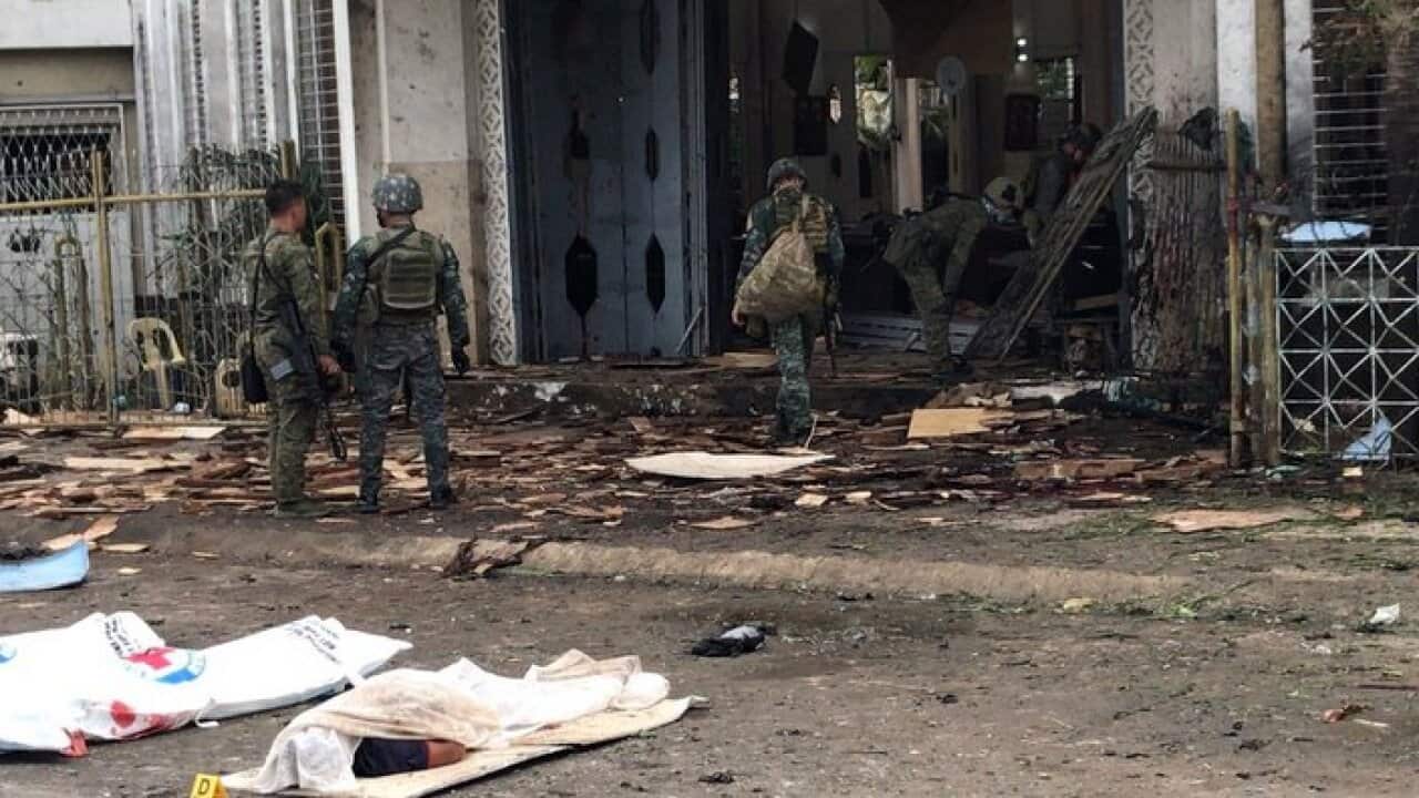 Filipino soldiers gather evidences next to the covered bodies of victims in front of a church following explosions in Sulu, Philippines AEPA/PEEWEE BACUNO