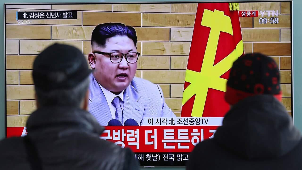 South Koreans watch a TV news program showing North Korean leader Kim Jong Un's New Year's speech, at the Seoul Railway Station.