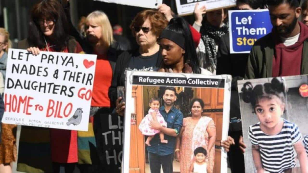 Photo of the Tamil asylum seekers, the Muragappan family carried by their supporter in a rally