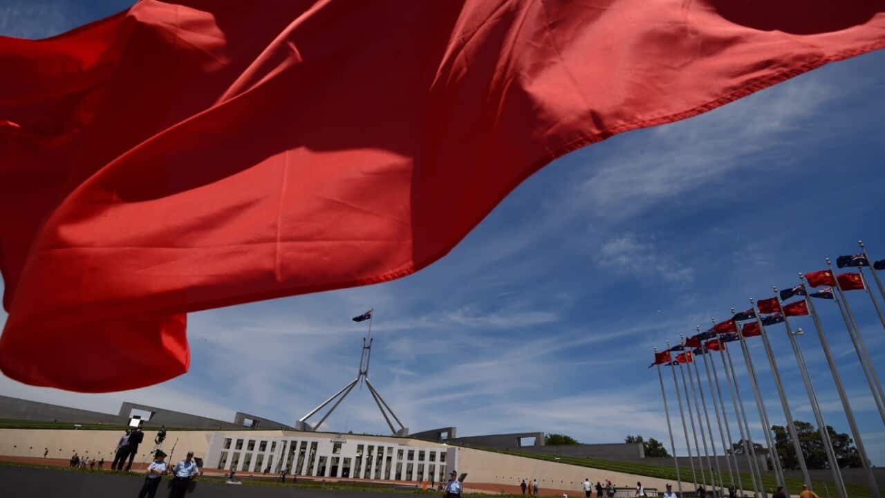 File: Chinese flags fly high outside the Australian Parliament House in Canberra