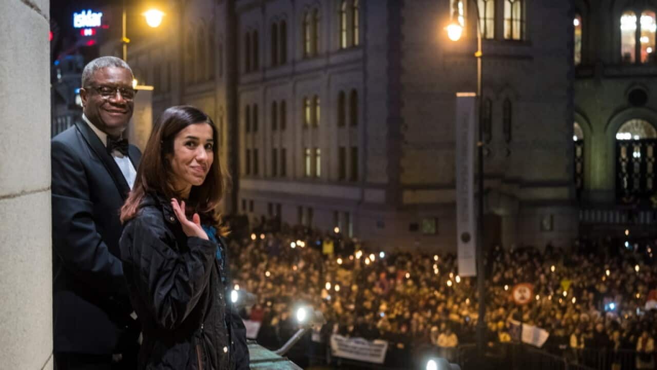 Nobel Peace Prize laureates Dr Denis Mukwege (L) and Nadia Murad watch the torchlight parade in Oslo, Norway