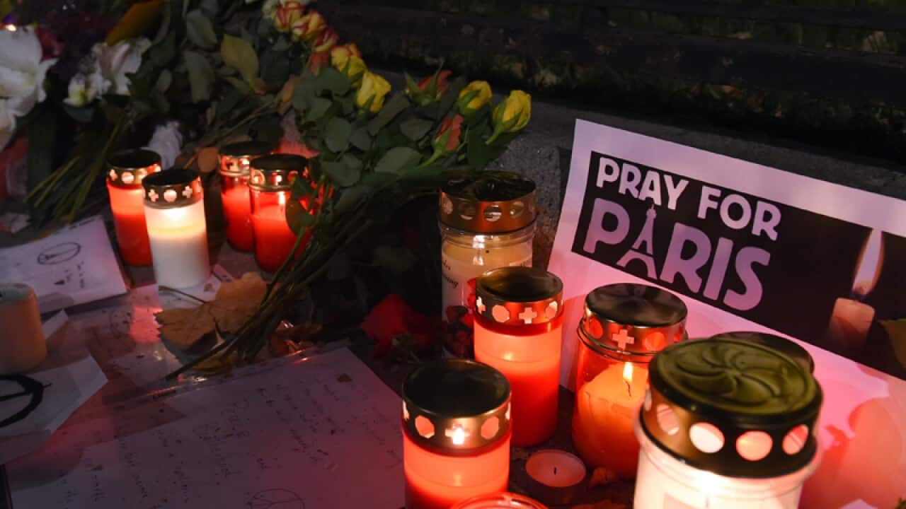 People light candles and place flowers to pay tribute for the victims