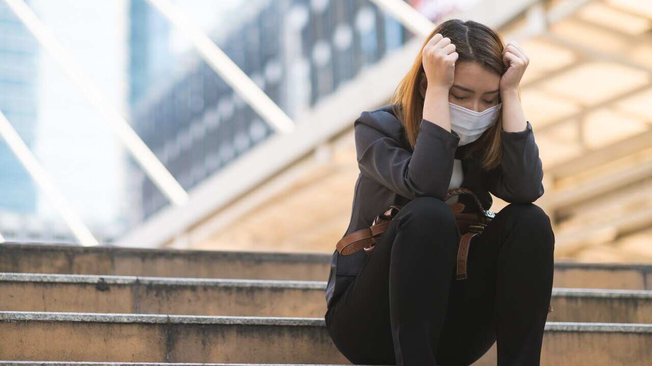 Unemployed businesswoman depressed sitting on a path due to company bankrupted while coronavirus spreading situation