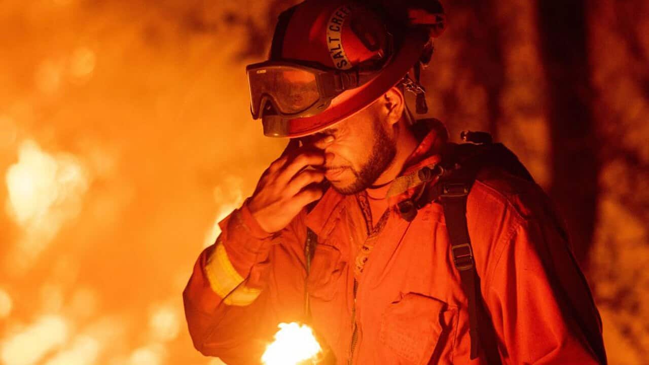 A firefighter pauses while battling fires near Redding, California.
