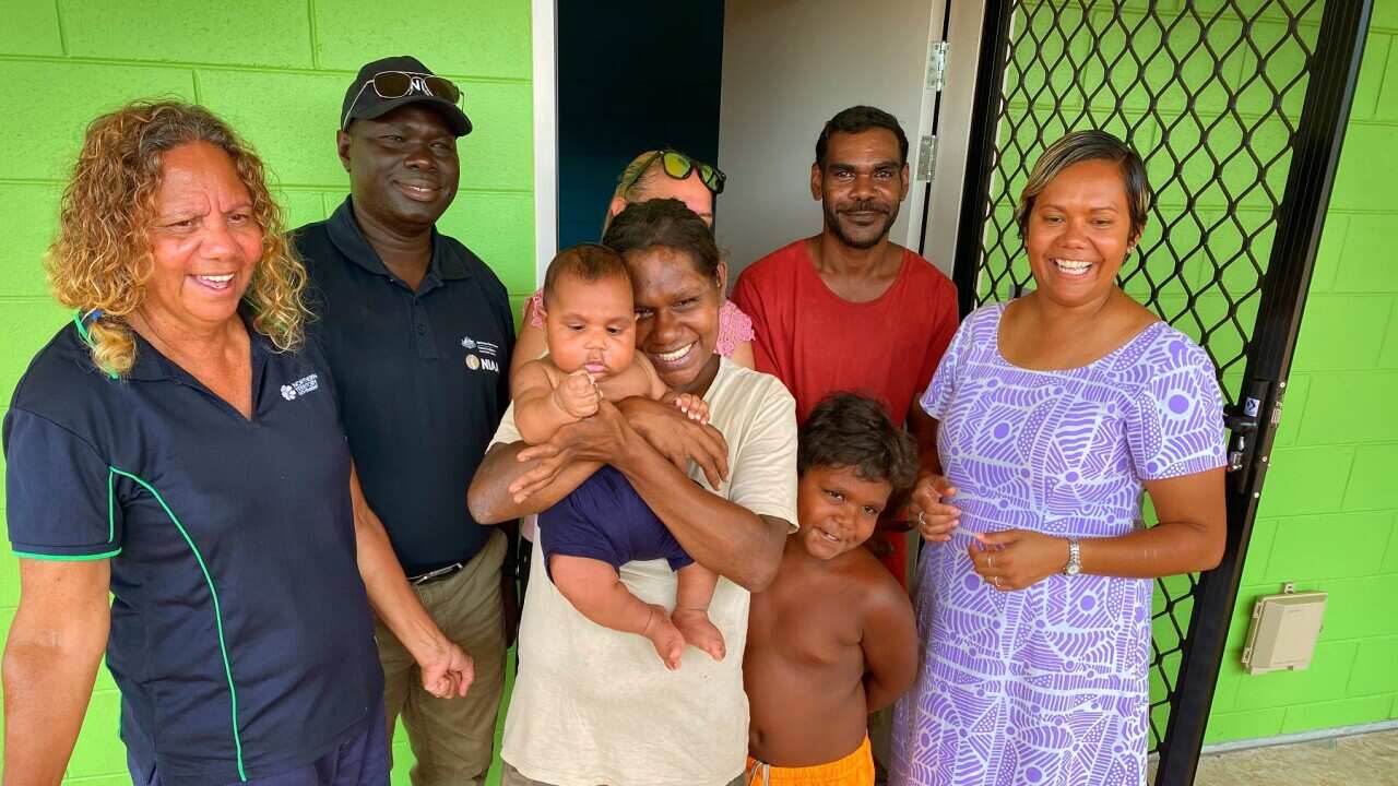 Lucille Papajua (left) and her family receive the keys to their new home with Minister Selena Uibo (right) (SBS).jpg