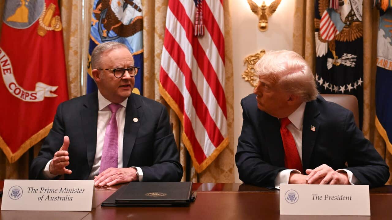 Anthony Albanese and Donald Trump, sitting next to each other at a table. There are various flags behind them, and small placards that say “The Prime Minister of Australia“ and “The President“.