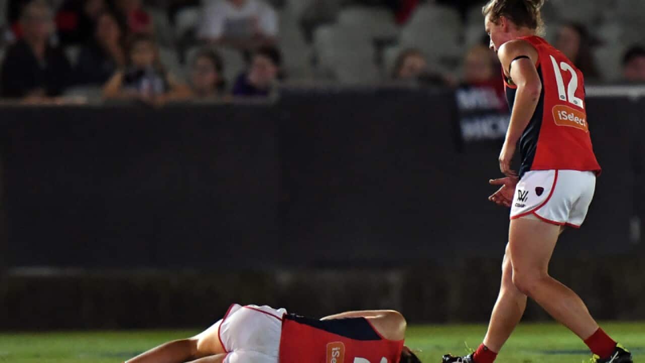 Meg Downie of Melbourne on the ground after being knocked out