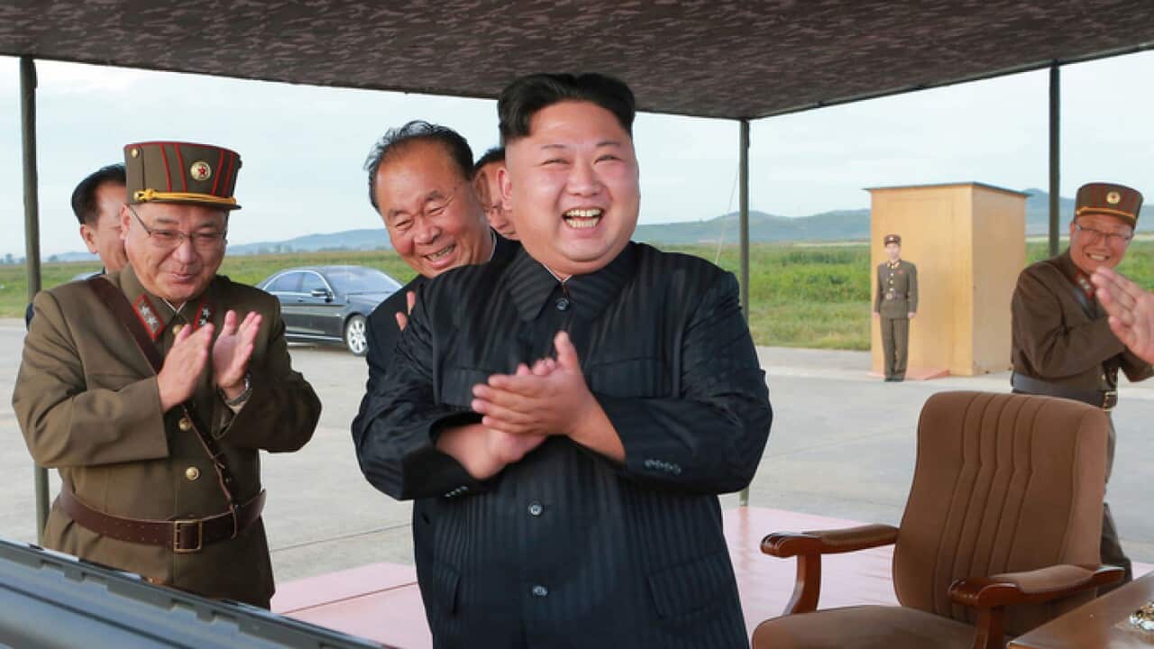 Image released on Sept 16 2017 of North Korean leader Kim John Un celebrating what was said to be test launch of intermediate range Hwasong-12 missile