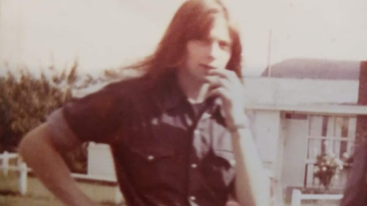 Tony Santi standing in front of a house.
