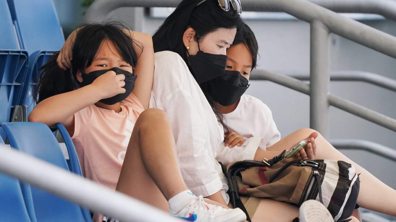 Spectators wear face masks to combat smoke haze during an Australian Open practise session at Melbourne Park in Melbourne, Wednesday, January 15, 2020. (AAP Image/Michael Dodge) NO ARCHIVING, EDITORIAL USE ONLY