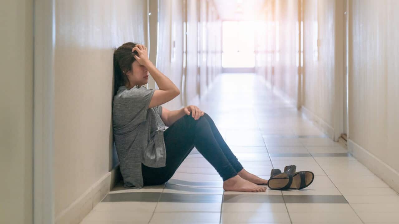woman suffering from depression sat in the corridor and cried.
